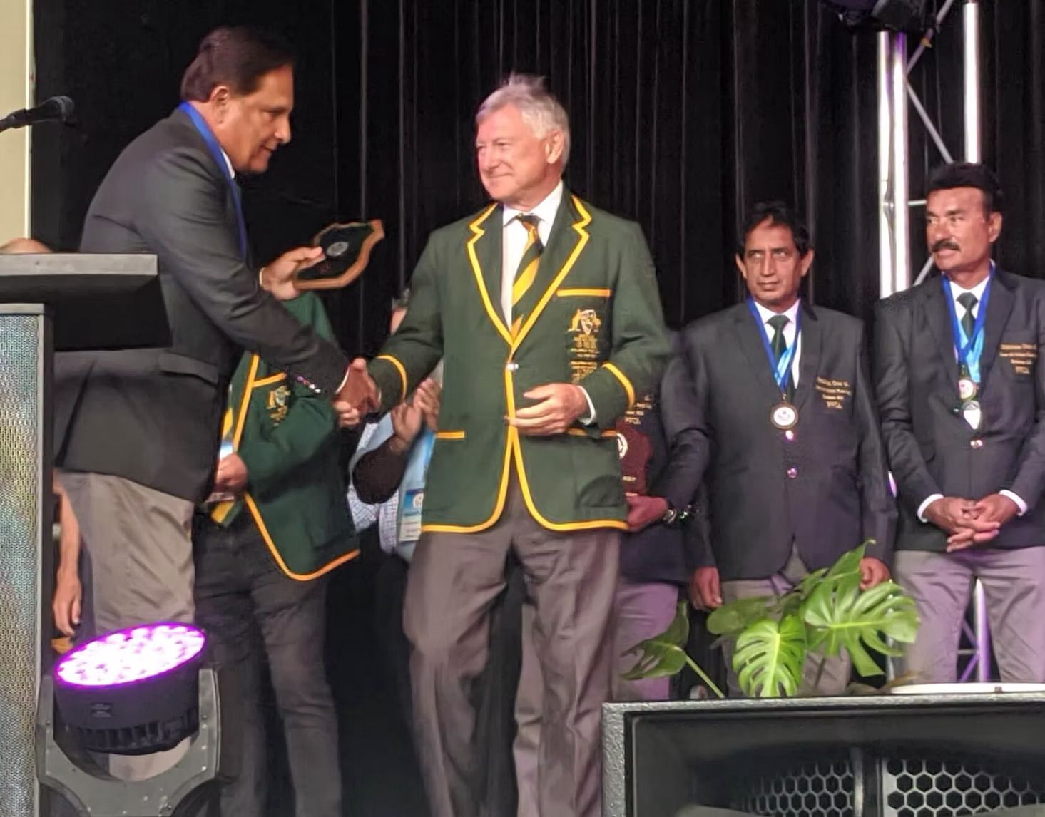 World Cup 2023 Man in suit presents medal to a man in green blazer