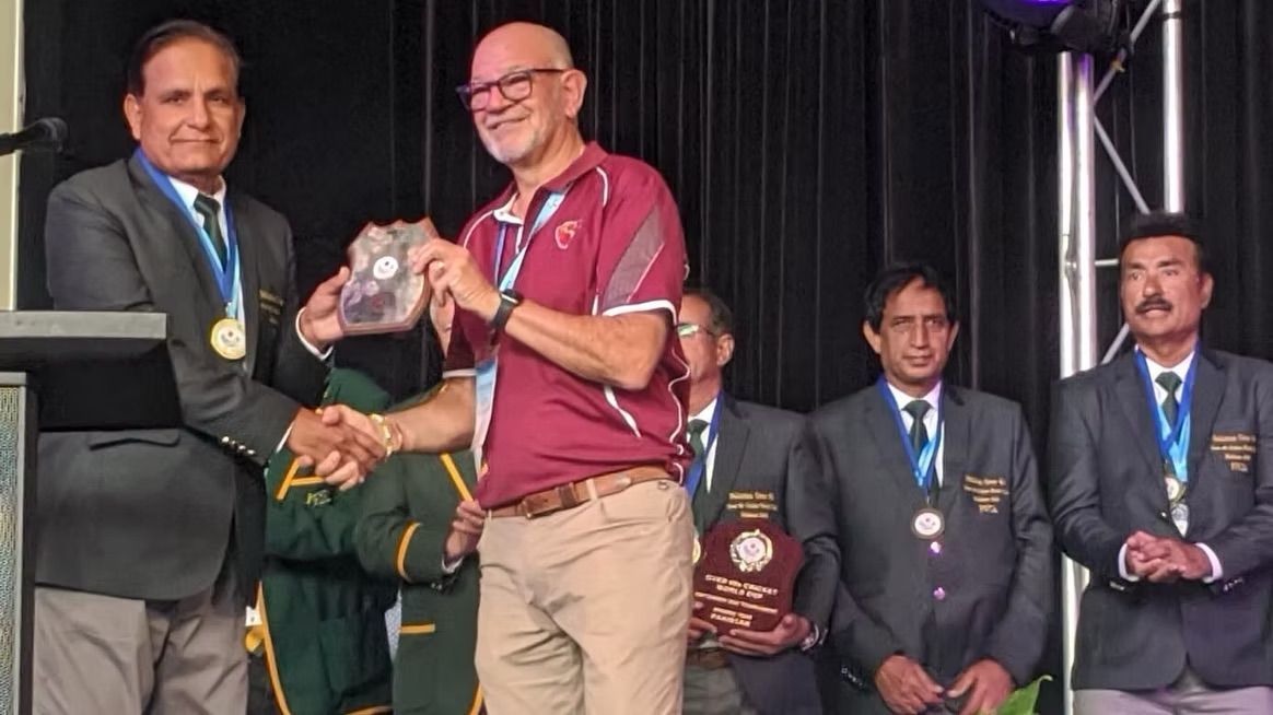 World Cup 2023 Man in gray suit presents award to a man in maroon