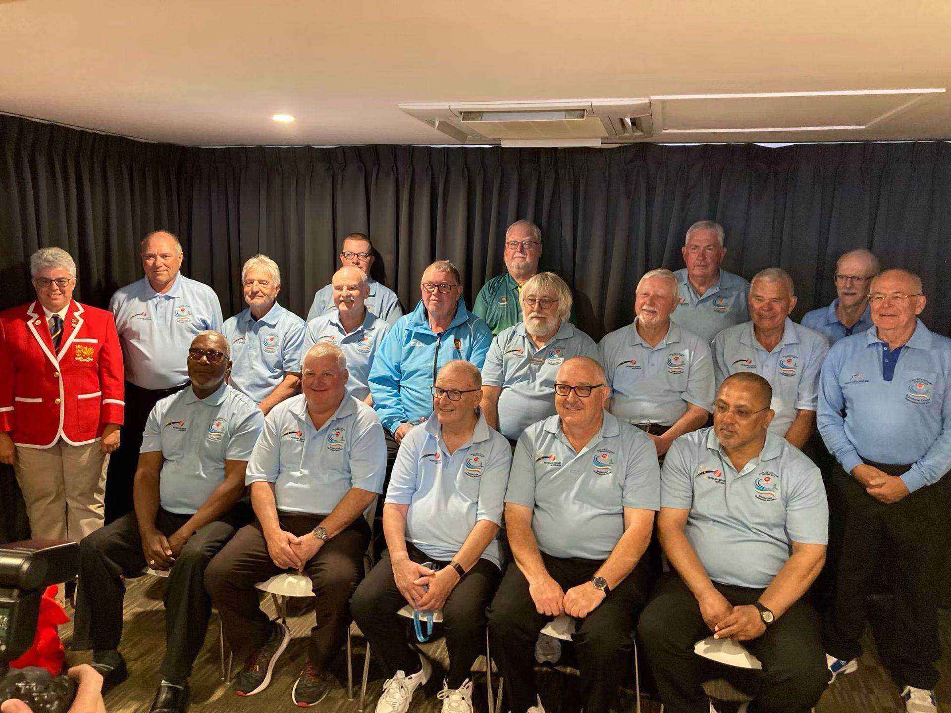 World Cup 2023 Group of men in blue shirts and a red blazer, posing for a photo