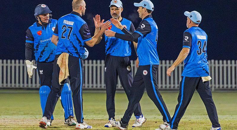 Cricket team in blue uniforms celebrating