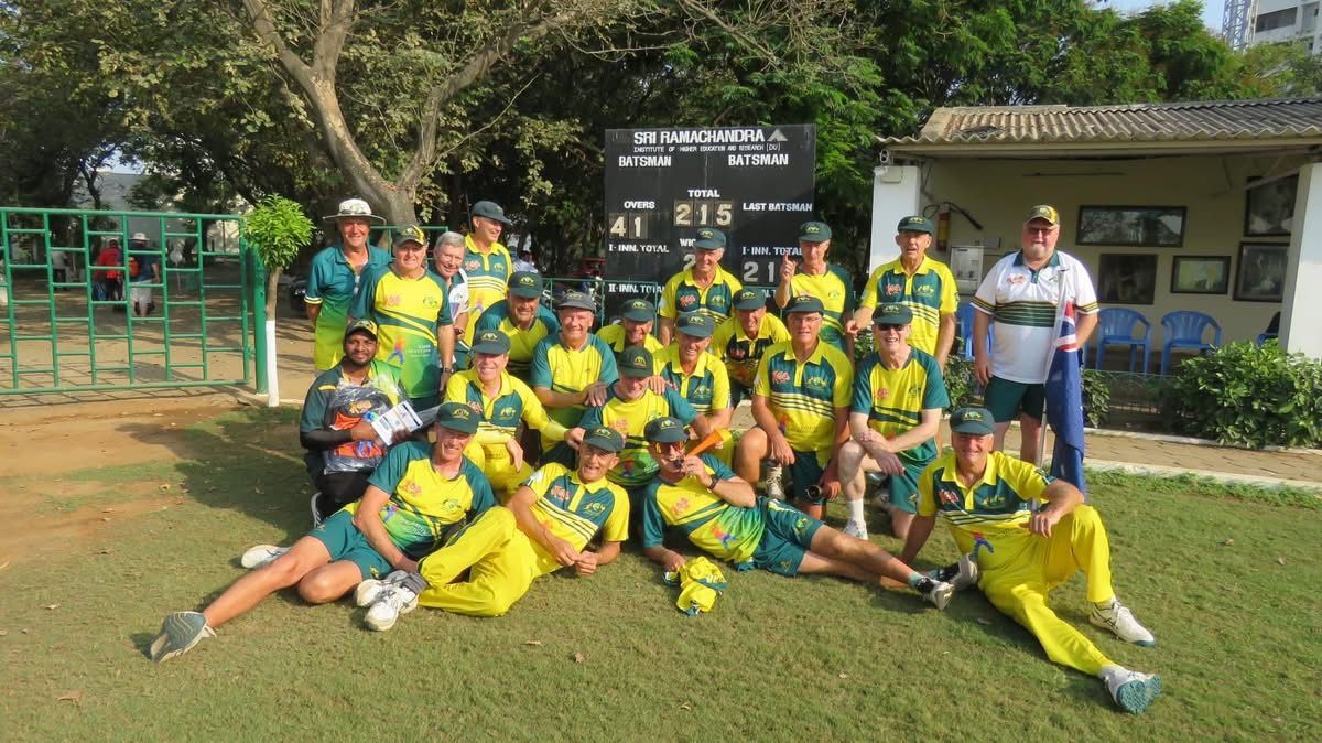Cricket team in yellow and green uniforms pose on a grassy field