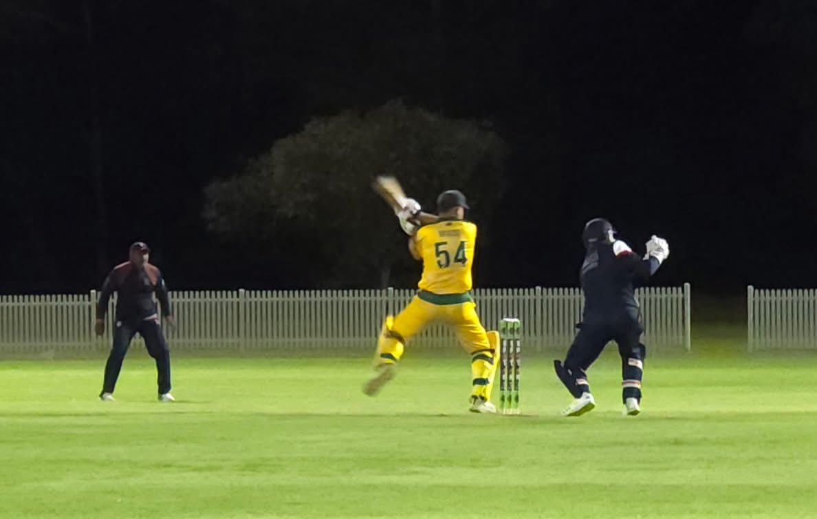 Cricket player in yellow and green uniform batting