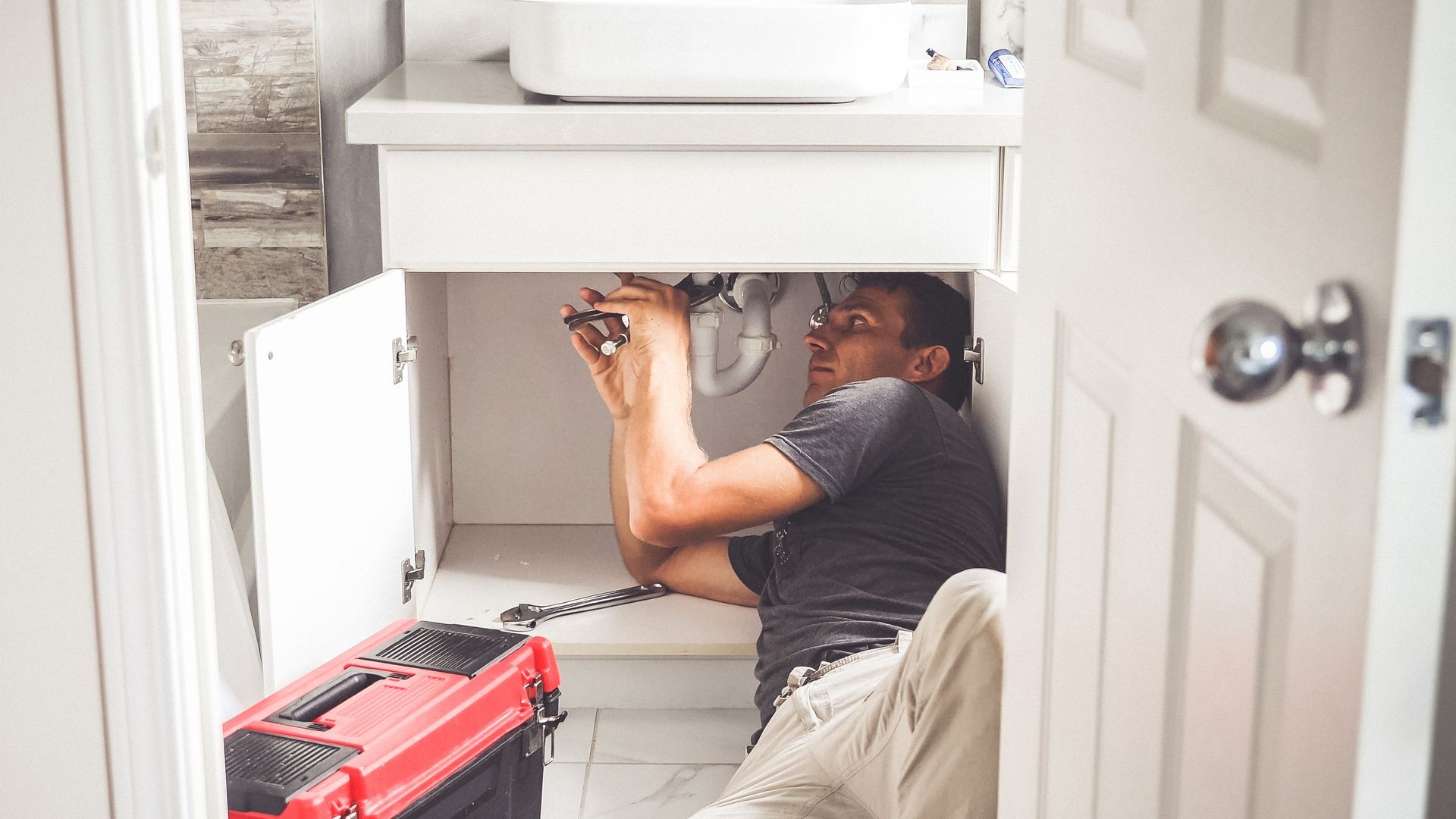 Worker Repairs Sink in the Bathroom — Santa Margarita, CA — RSM Plumbing