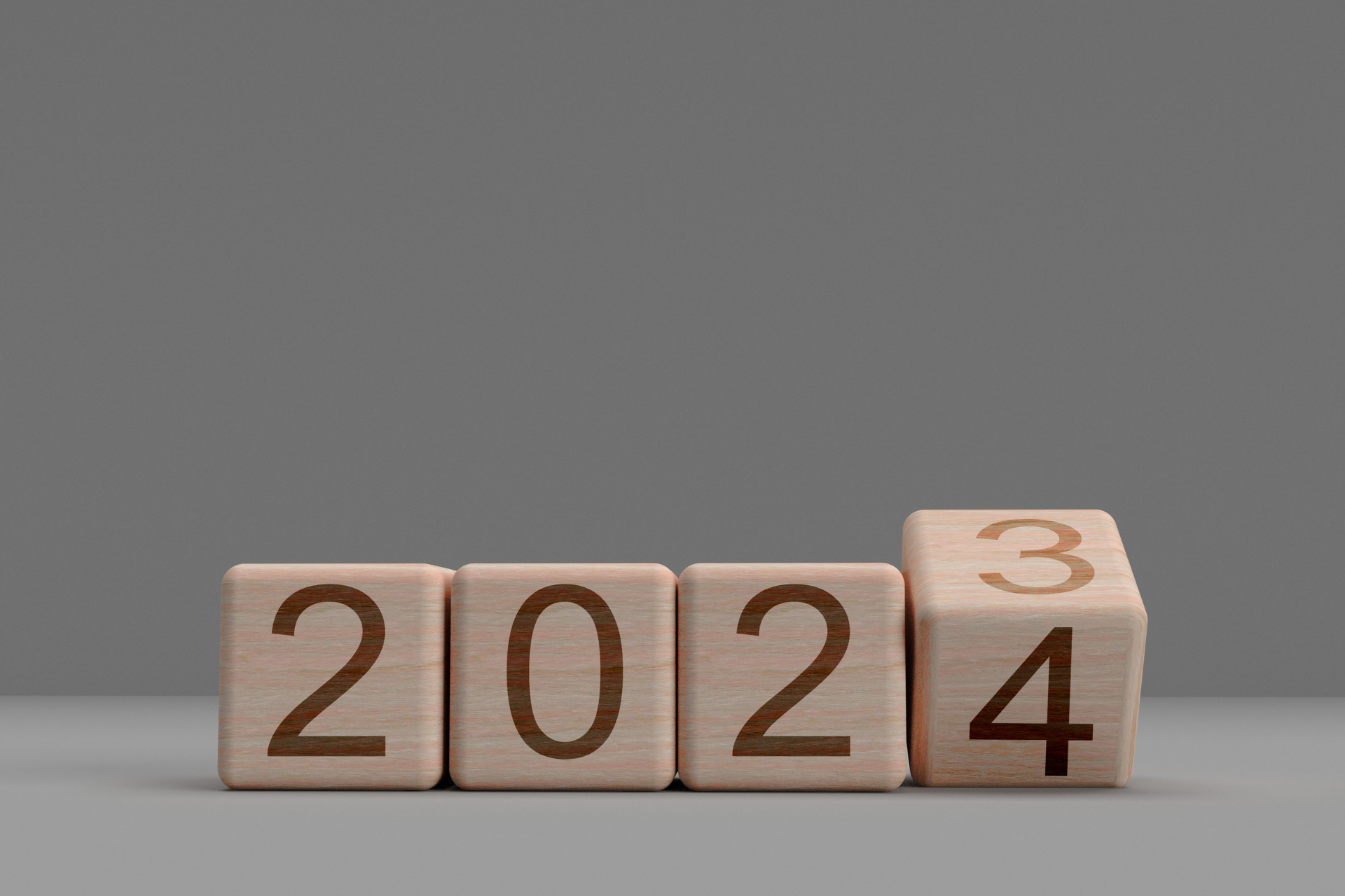 The numbers 2024 are written on wooden cubes on a gray background.