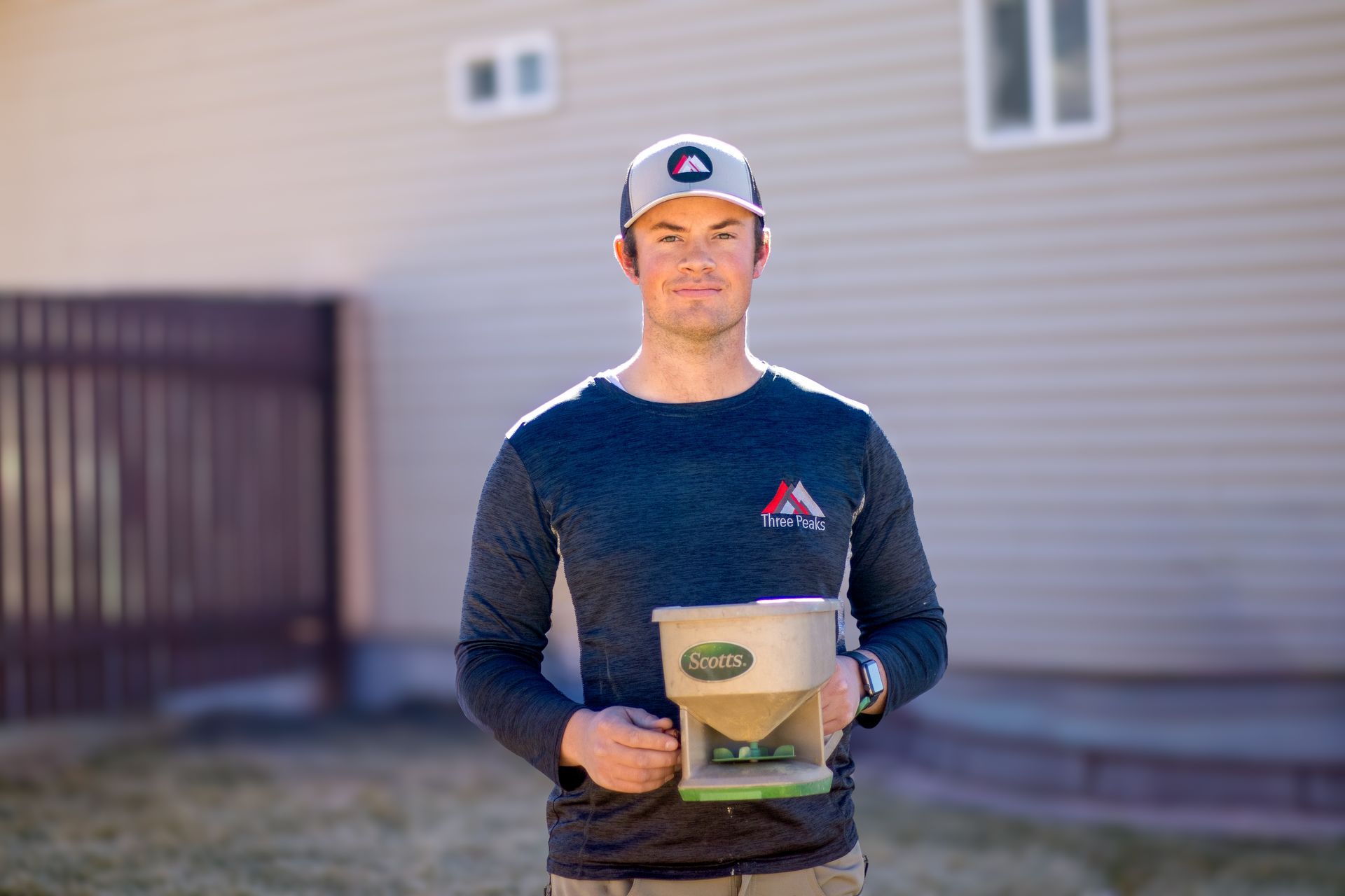 A Three Peaks Pest Control technician granulating a home in Parowan Utah.
