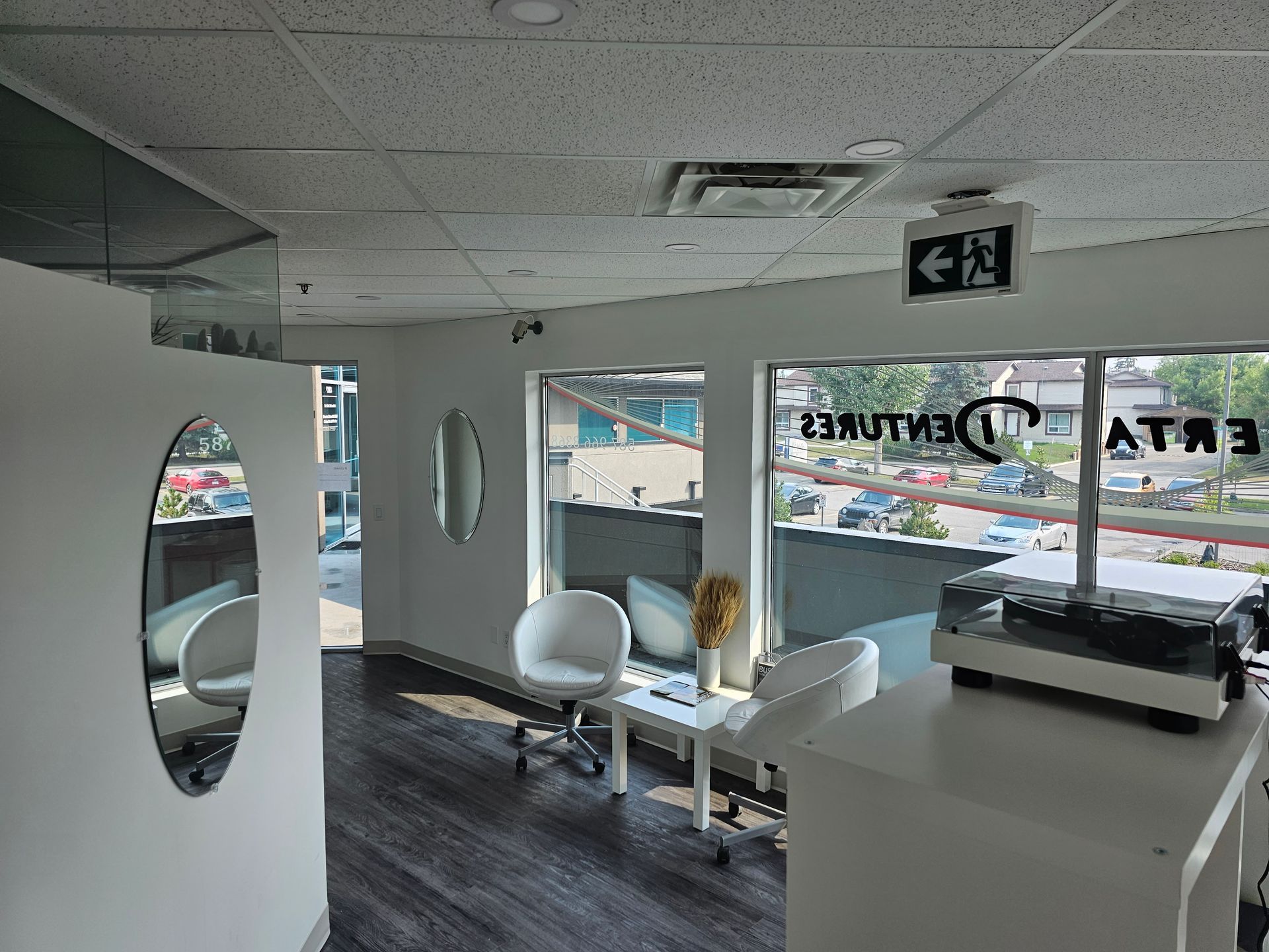 Bright, modern storefront with white chairs, a reception counter, and large front windows looking outside