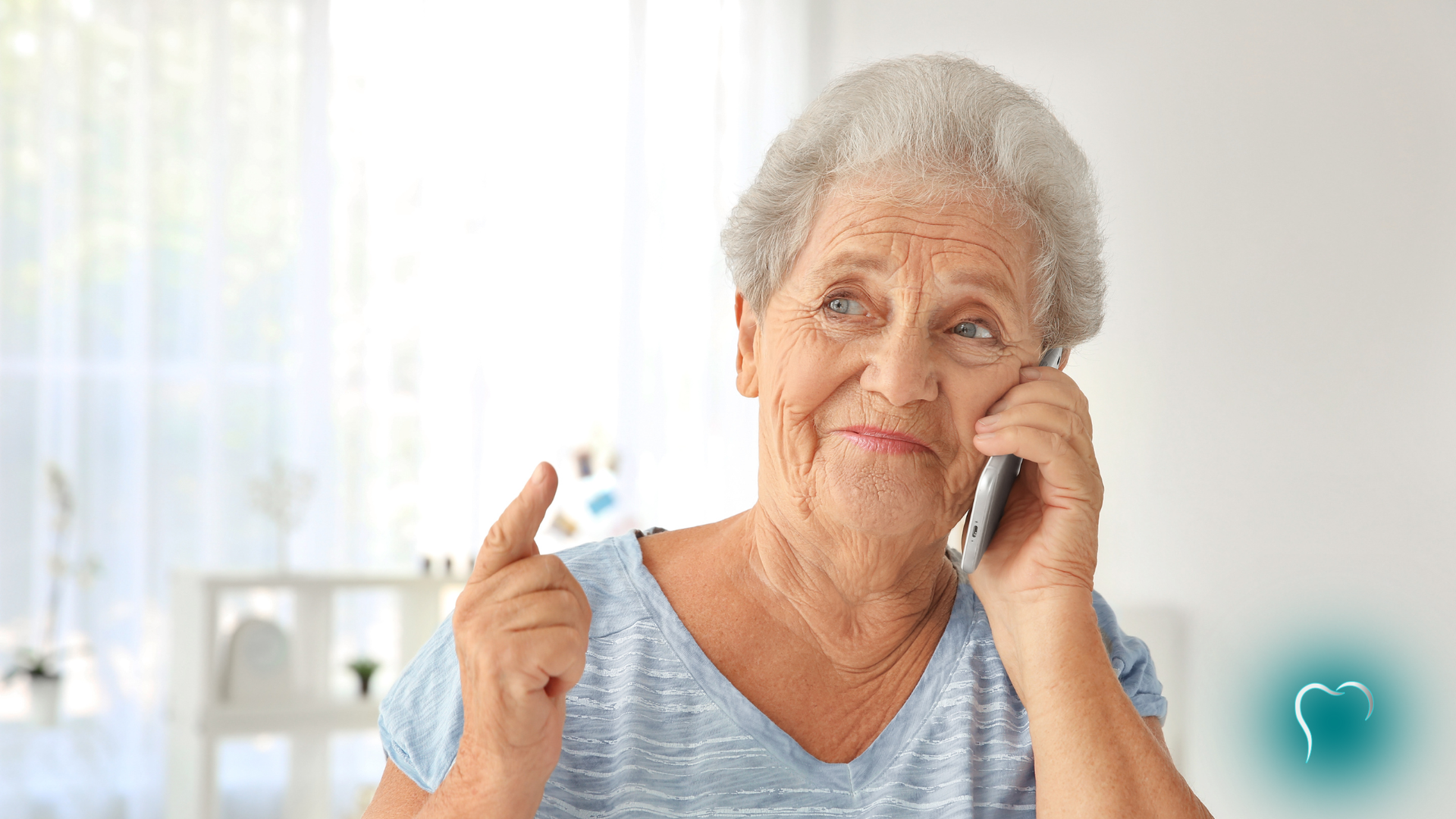 Elderly woman holding a phone and a blister pack, looking relieved in a bright room