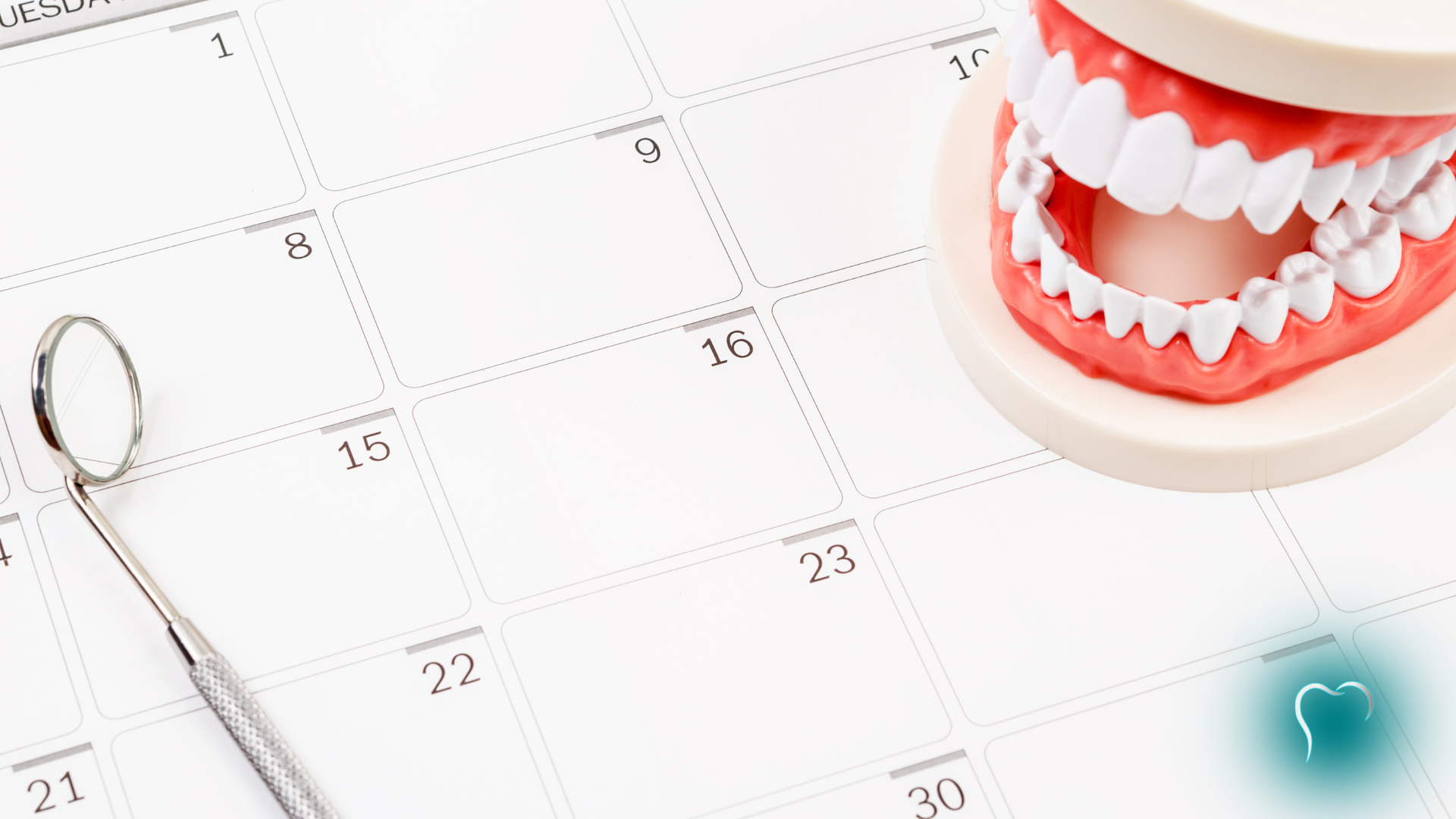 Dental model and mirror on a calendar, suggesting a scheduled dental appointment