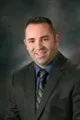 A man in a suit and tie is smiling for the camera.