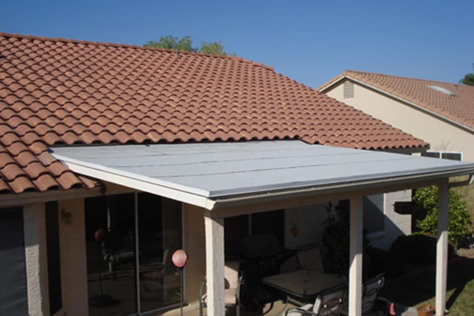 Back patio with a white awning beneath a red tile roof on a house