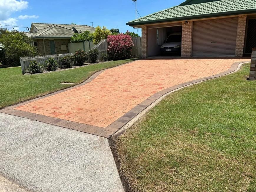 A Driveway Leading to a House With a Car Parked in the Garage — Derek's Dirty Deeds In Howard, QLD