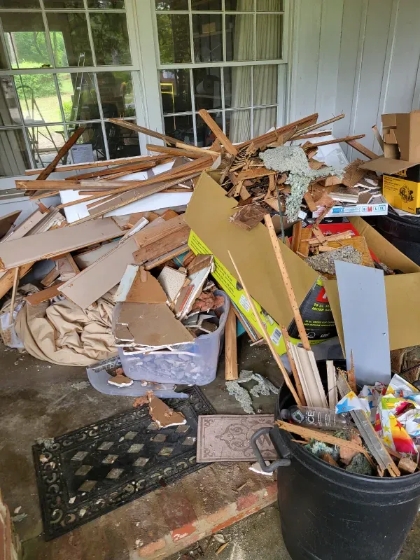 A pile of wood is sitting on the floor next to a bucket.