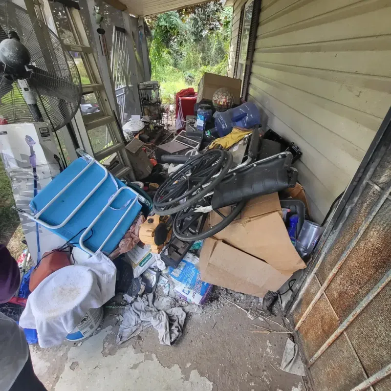 There is a lot of trash on the porch of a house.