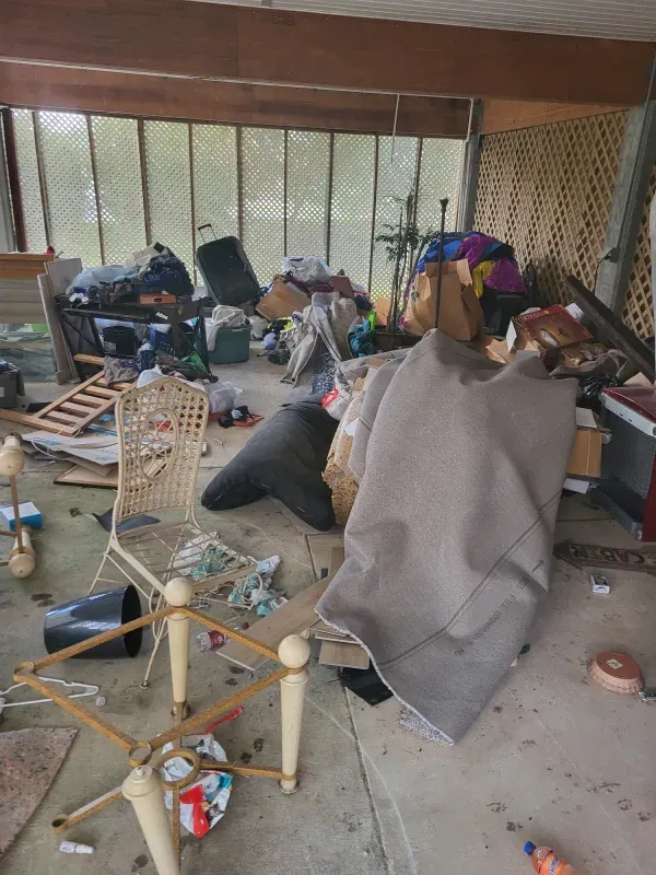 A living room filled with lots of furniture and trash.