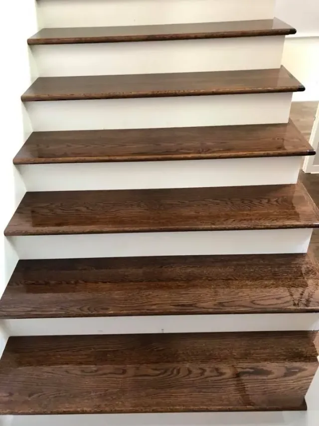 A close up of a set of wooden stairs with white risers.