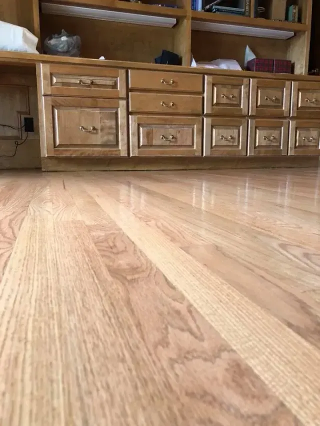 A wooden floor with drawers and cabinets in a living room.