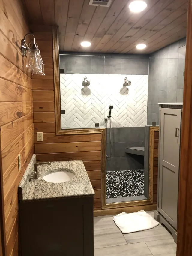 A bathroom with a sink and a walk in shower