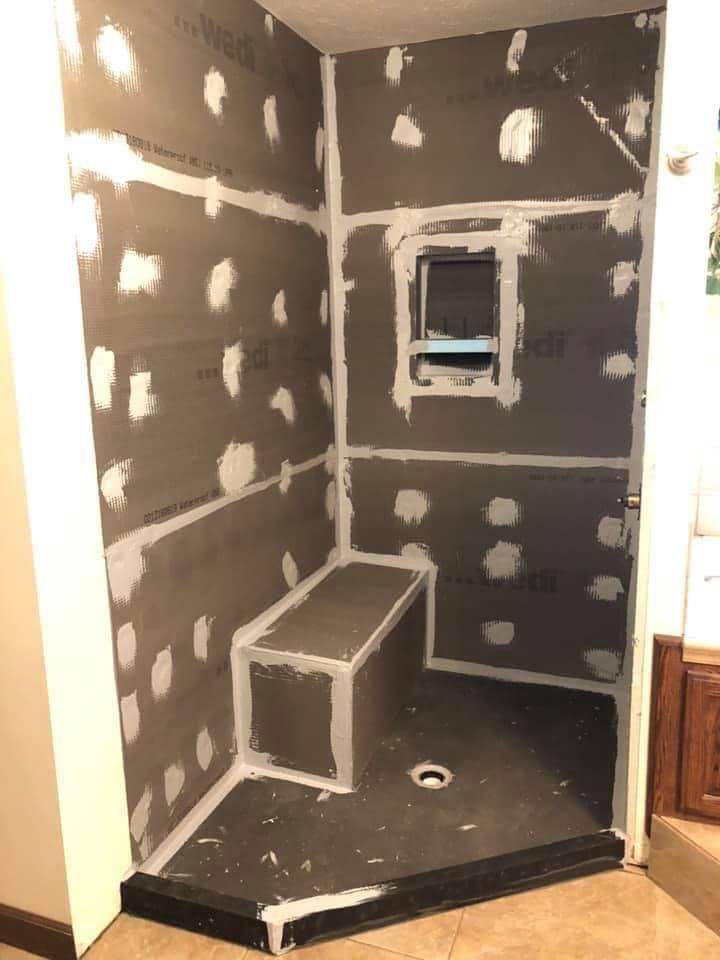 A bathroom is being remodeled with drywall and a window.