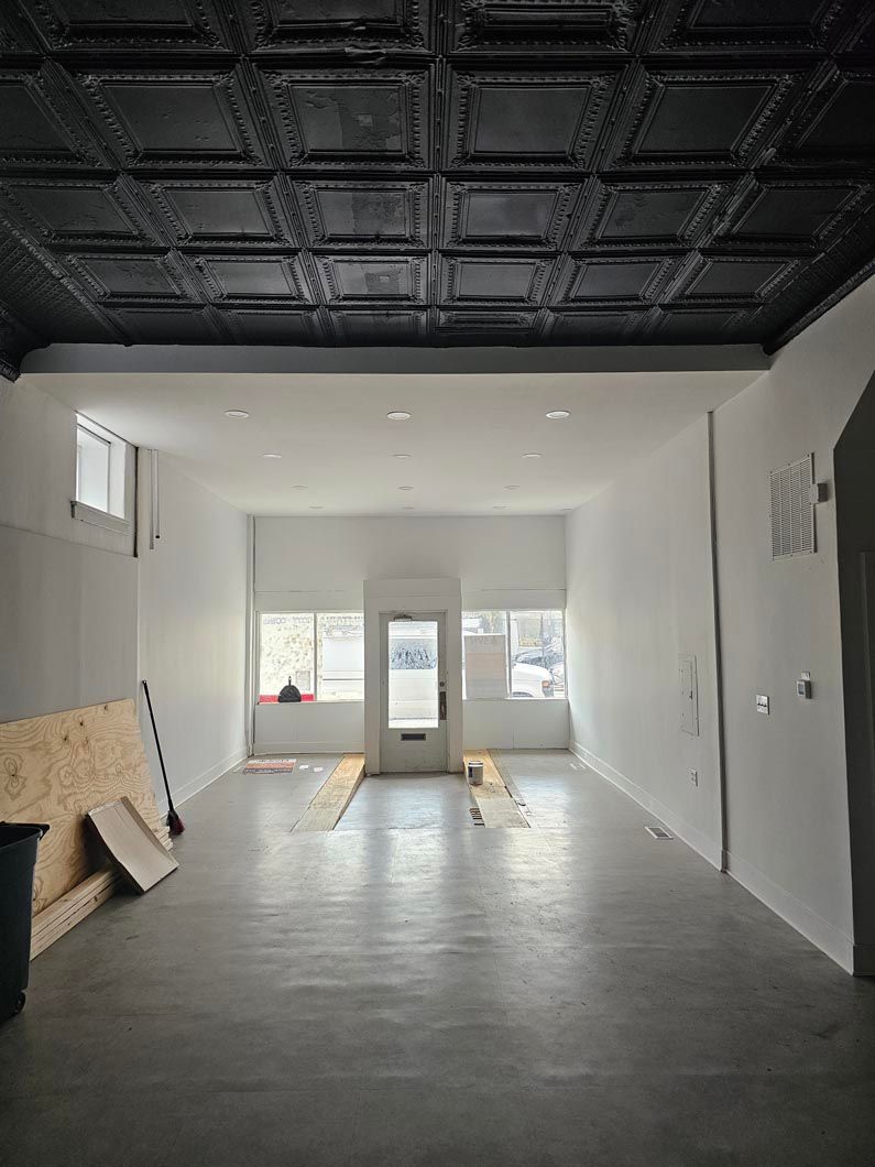 A large empty room with a black ceiling and white walls.