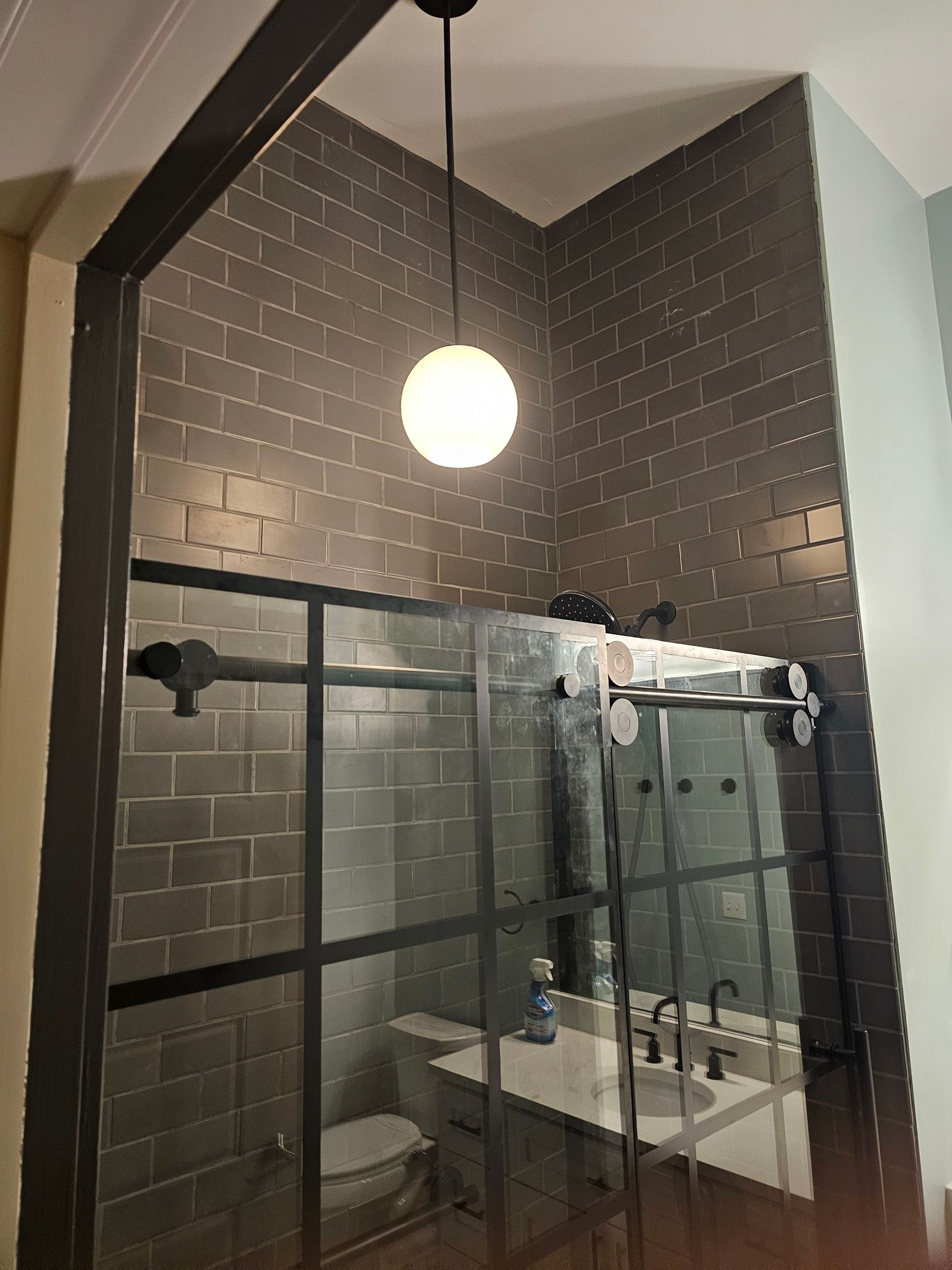 A bathroom with a toilet , sink , and shower.