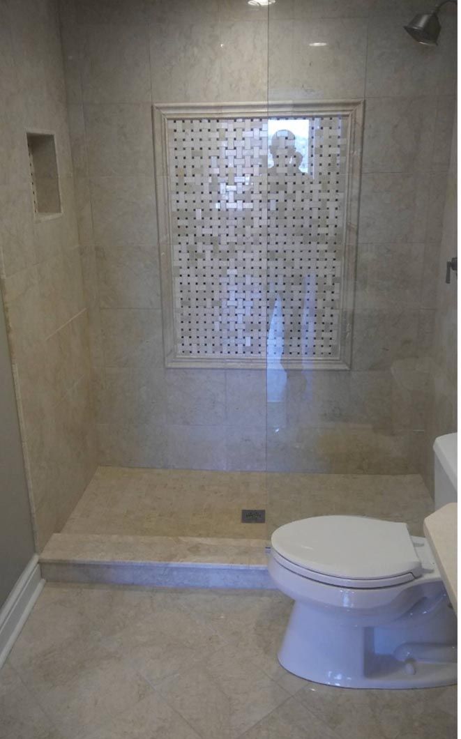 A bathroom with a toilet and a walk in shower