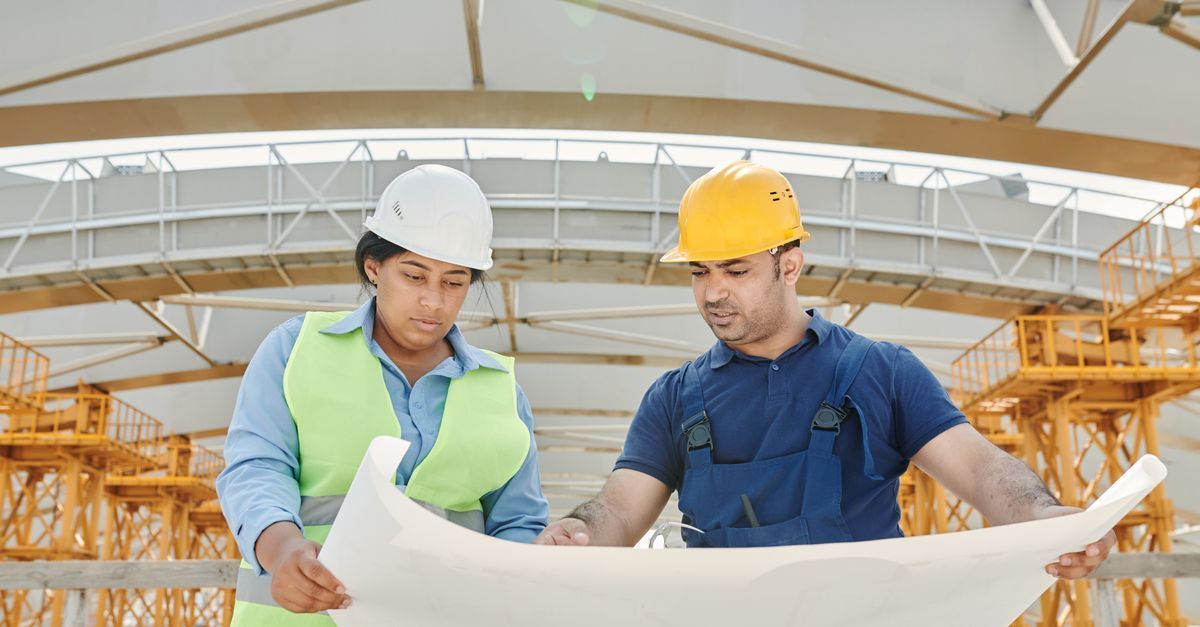 Ingenieros revisando planos de un proyecto de infraestructura con contrato mixto