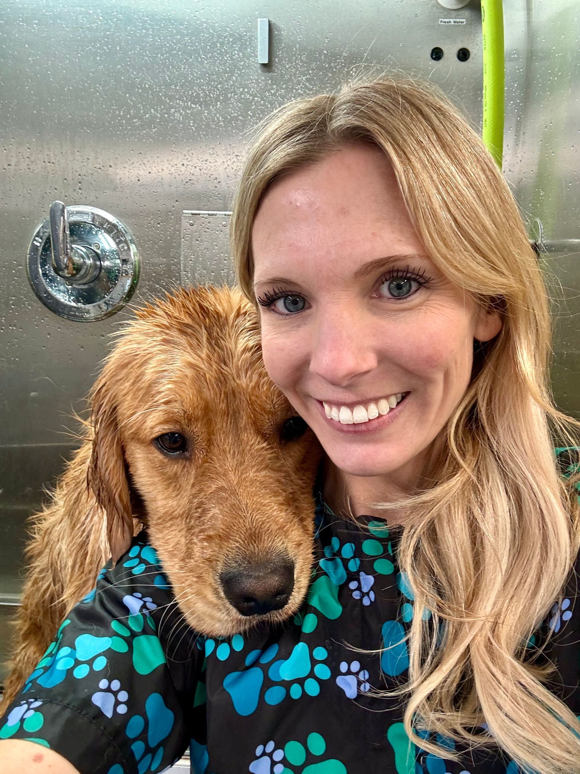 A woman is holding a dog in her arms and smiling.