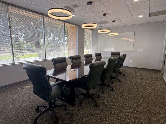 A small office with a desk and chairs in it.