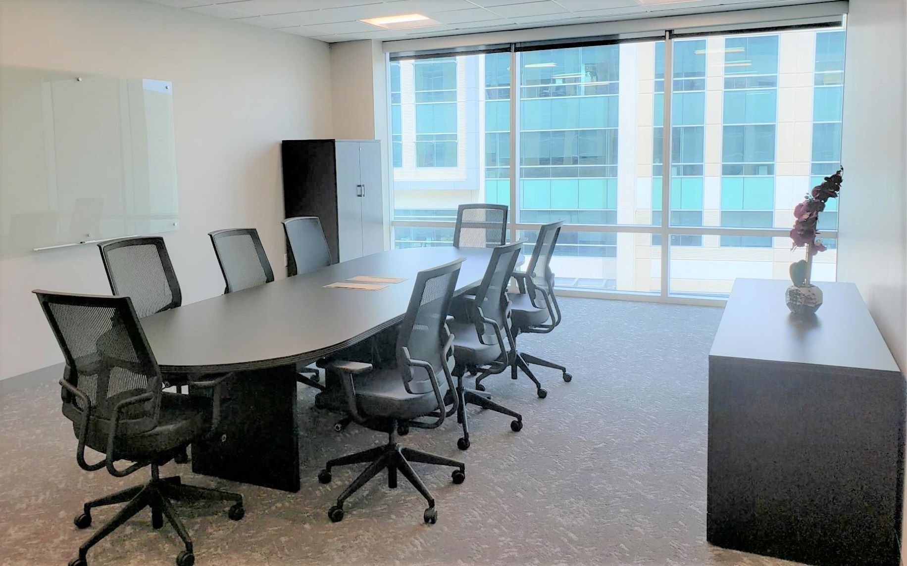 A conference room with a long table and chairs.