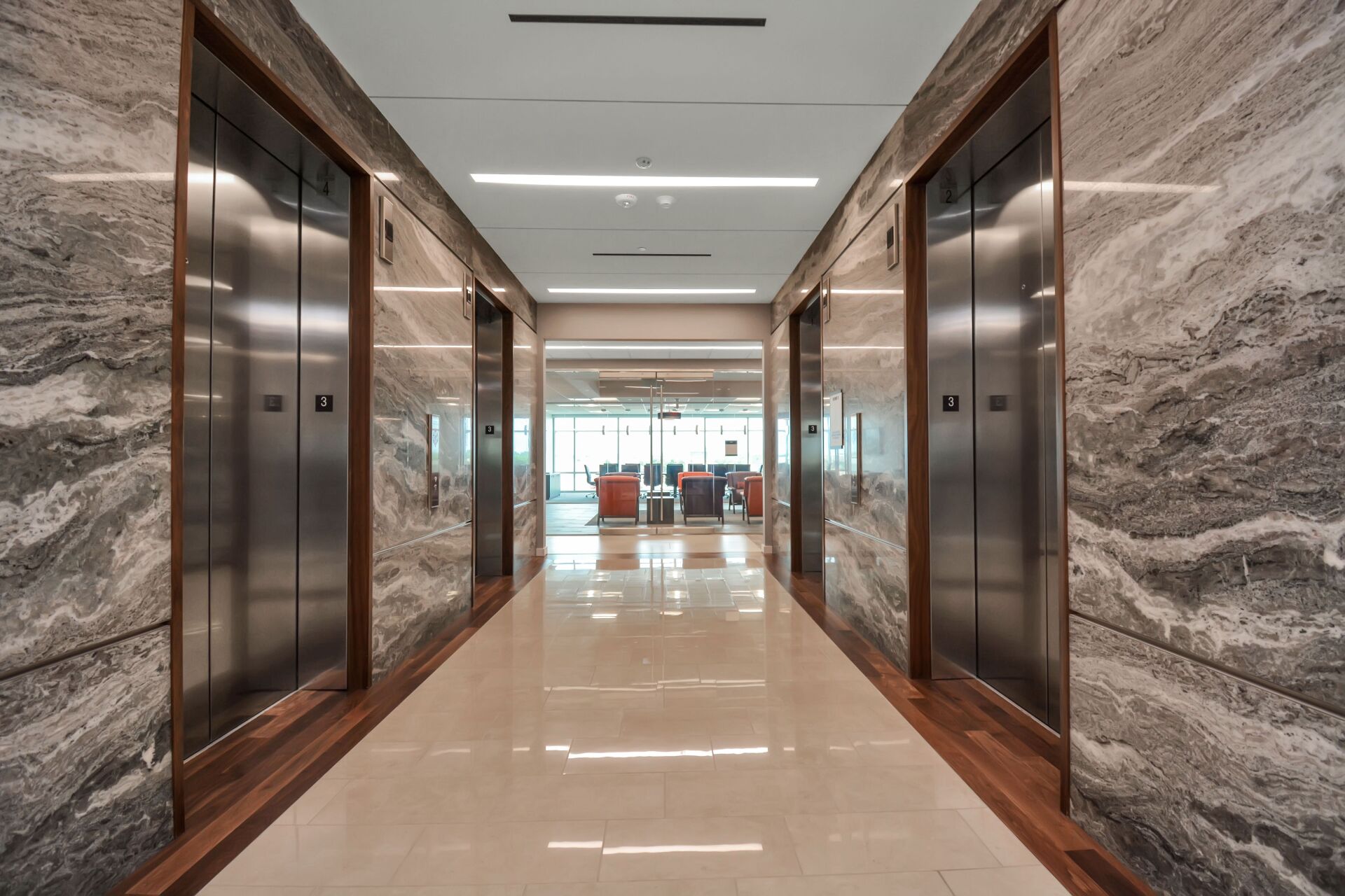 A long hallway with elevators in a building.
