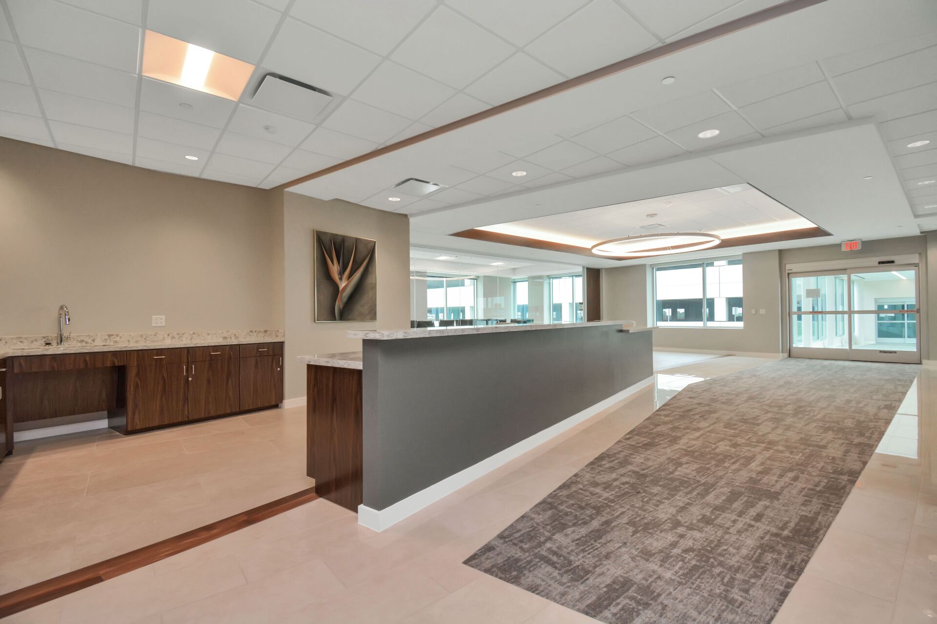 An empty lobby with a long counter and a carpeted floor.