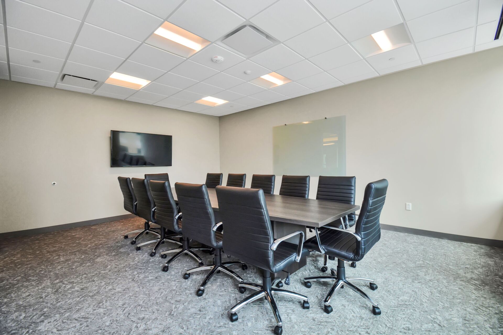 A conference room with a long table and chairs.