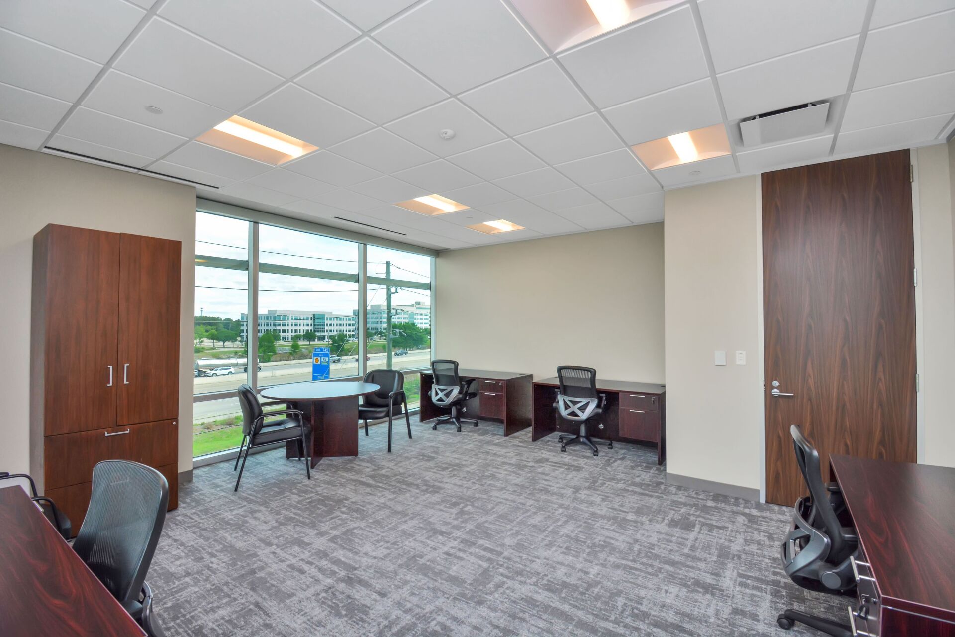 A large room with a lot of windows and desks and chairs.