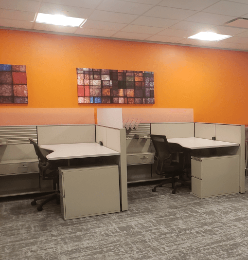A room with cubicles and a painting on the wall