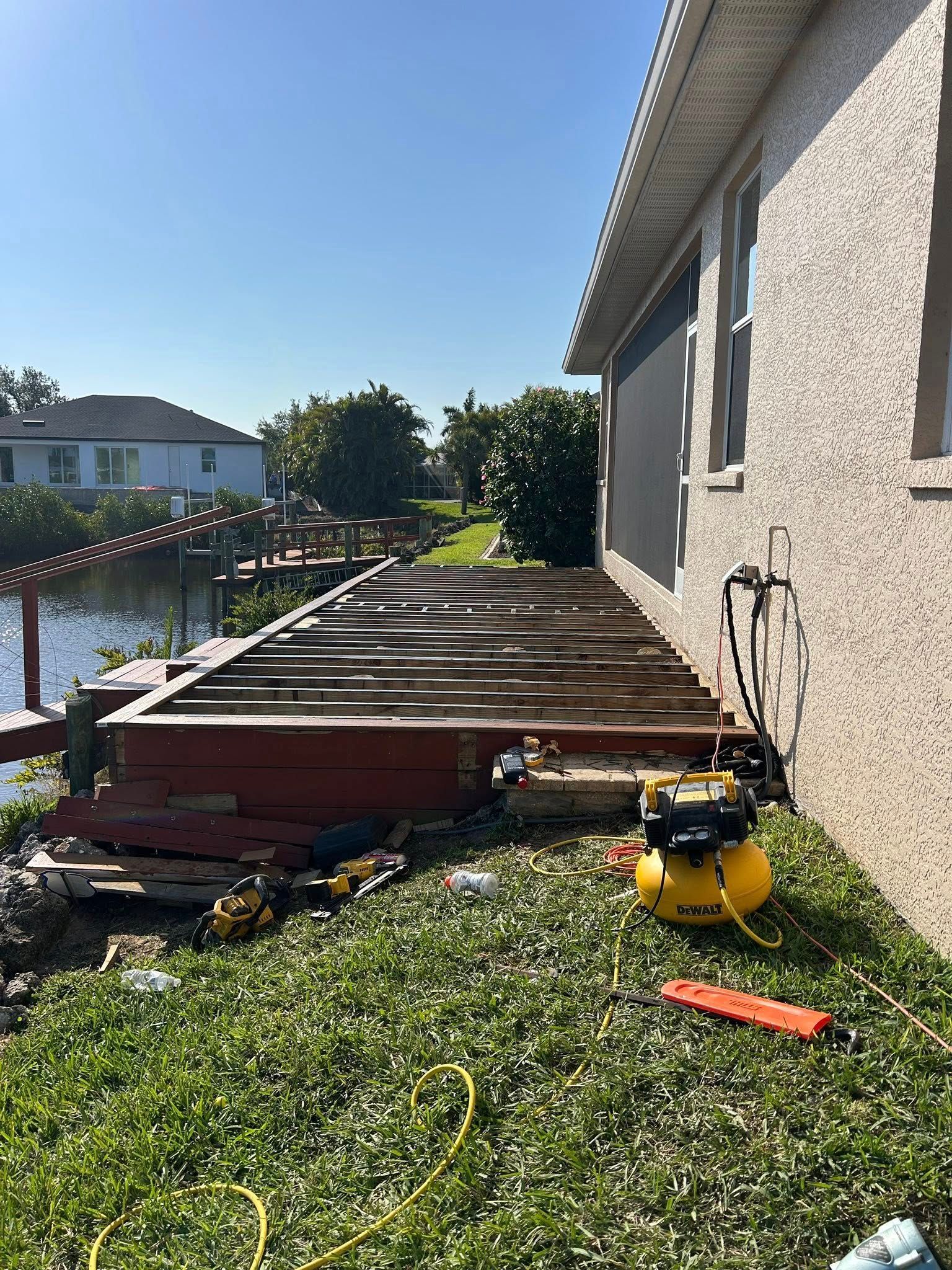 A house with a deck being built next to a body of water.