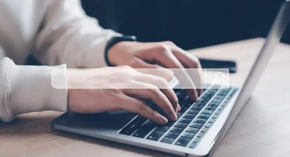 A person is typing on a laptop computer.
