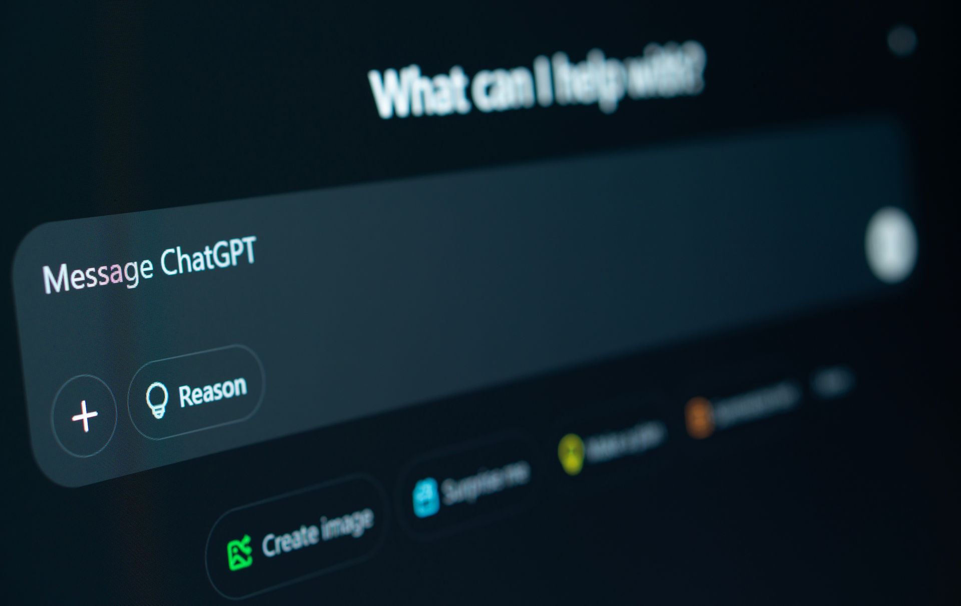 ChatGPT home screen with message box and “What can I help with?” prompt on a dark blurred background
