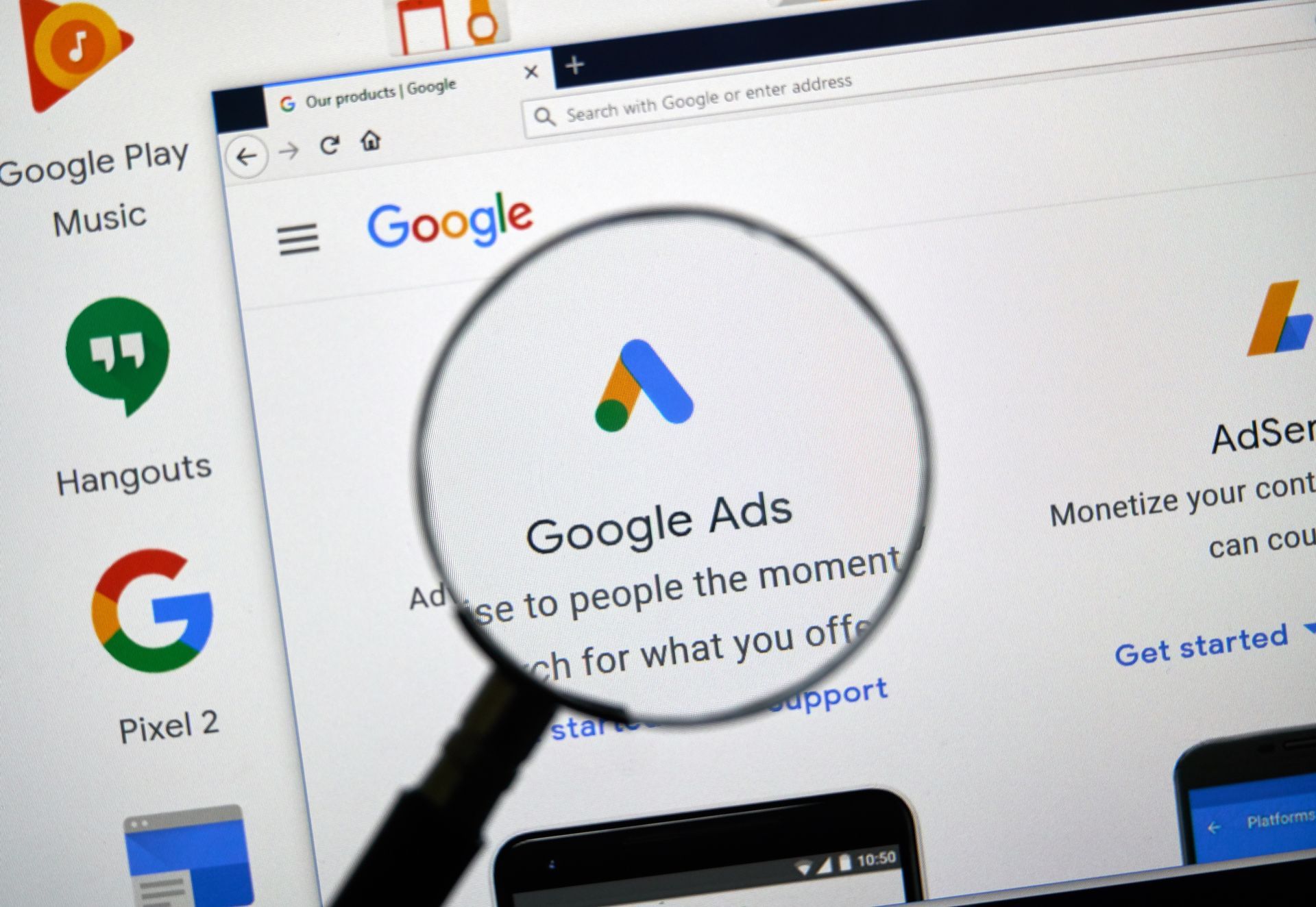 Magnifying glass over Google Ads webpage on a laptop screen