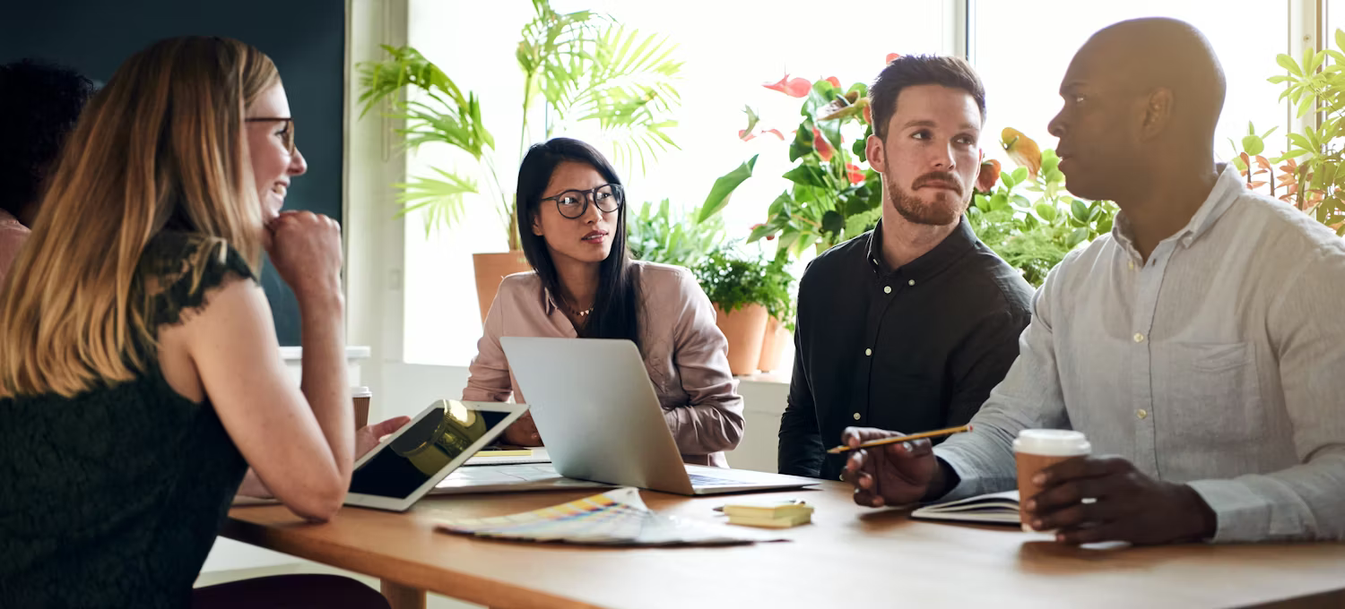 A group of people are sitting around a table having a meeting. A group of people are sitting around a table having a meeting.