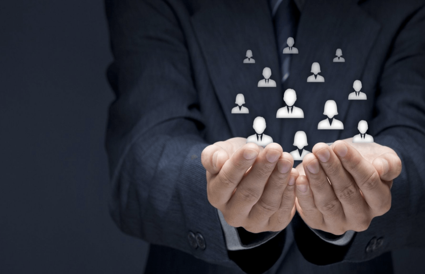 A man in a suit is holding a group of people in his hands.