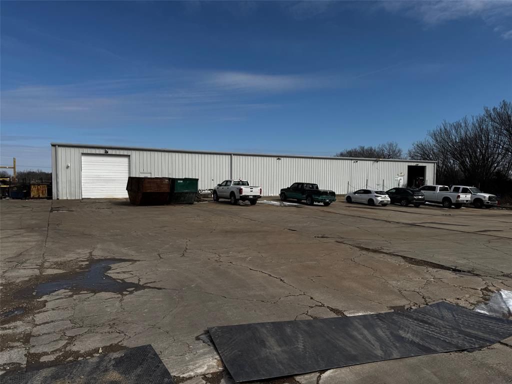 A row of trucks are parked in front of a large white building.