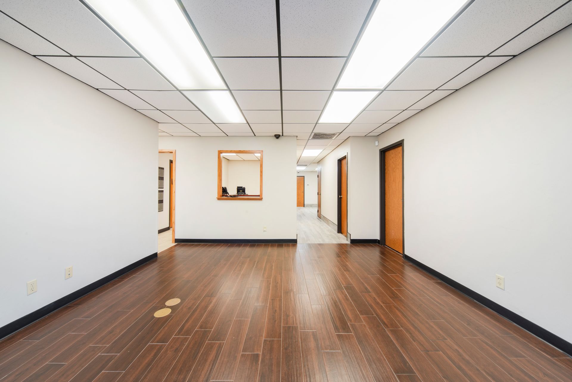 An empty room with wooden floors and white walls