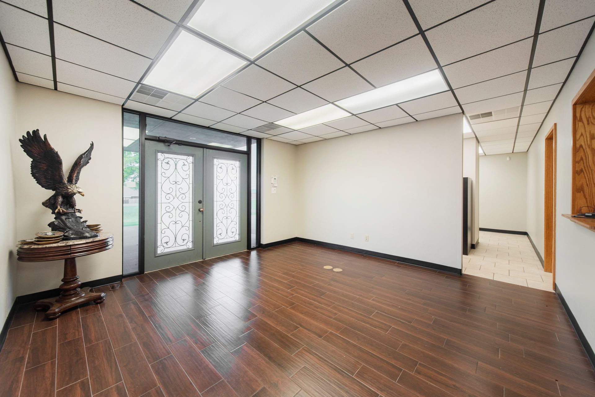 An empty room with a statue of an eagle on a table.