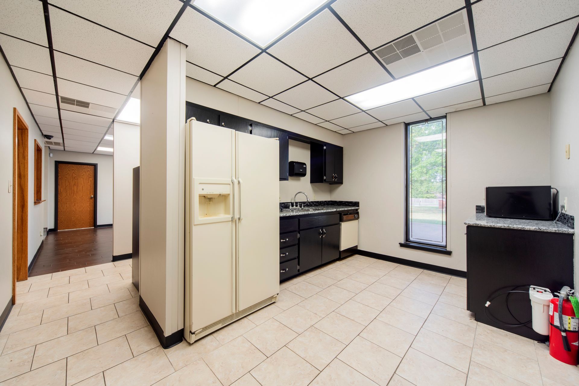 An empty kitchen with a refrigerator and a sink