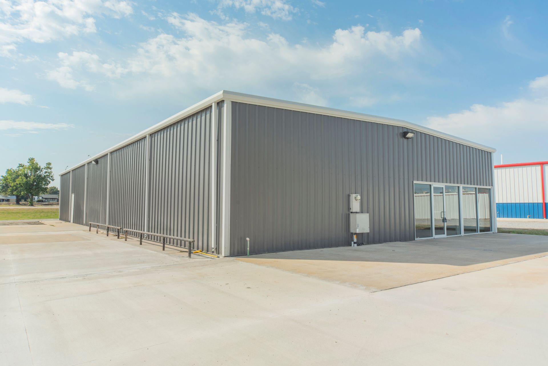 A large metal building with a concrete driveway in front of it