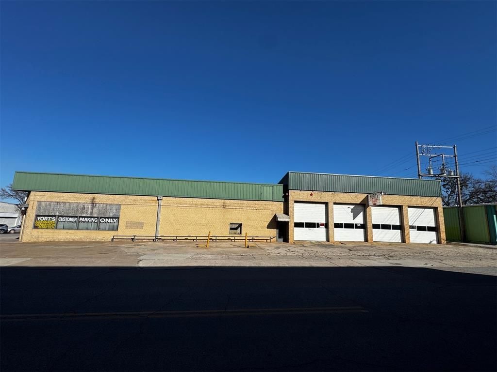 A large building with a green roof and white garage doors.
