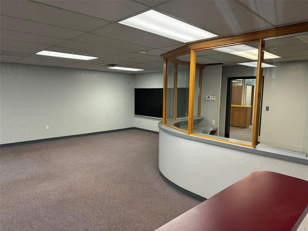 An empty room with a curved counter and a window