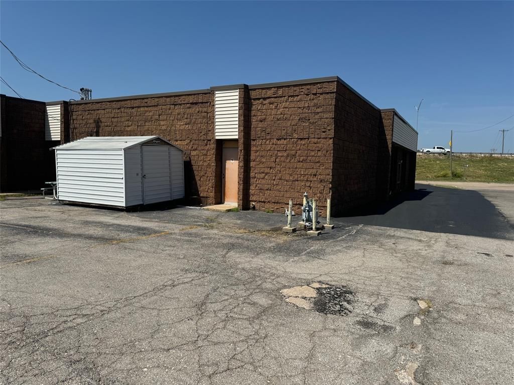 A brick building with a white shed in front of it.