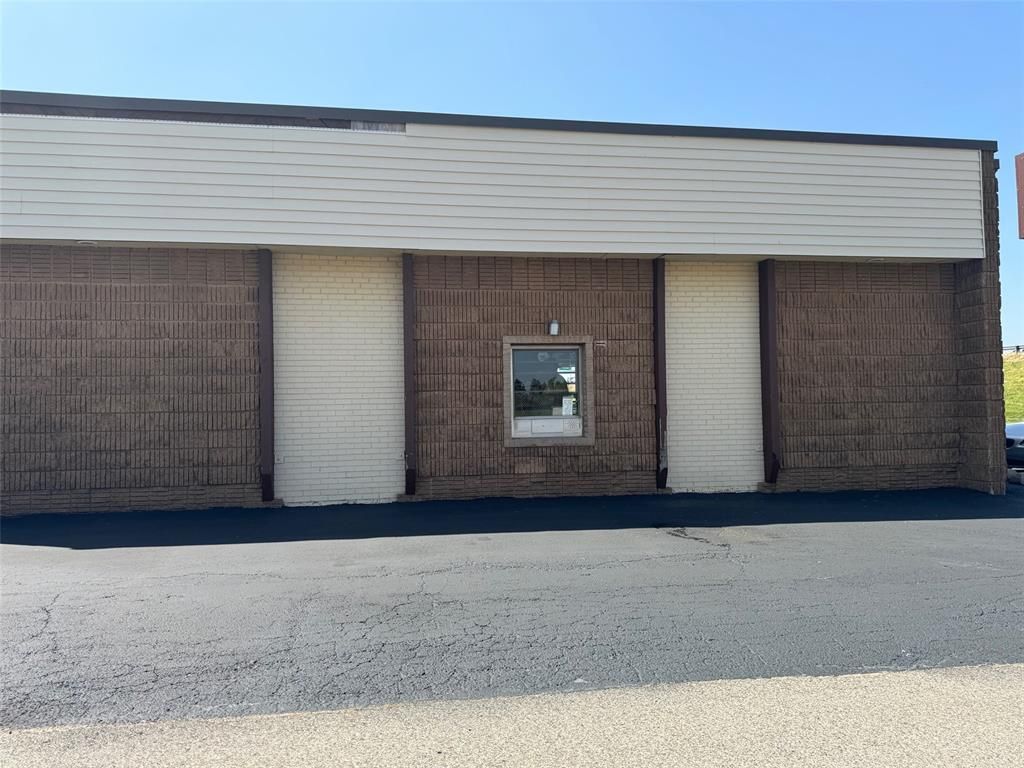 A large brick building with a white garage door and a window.