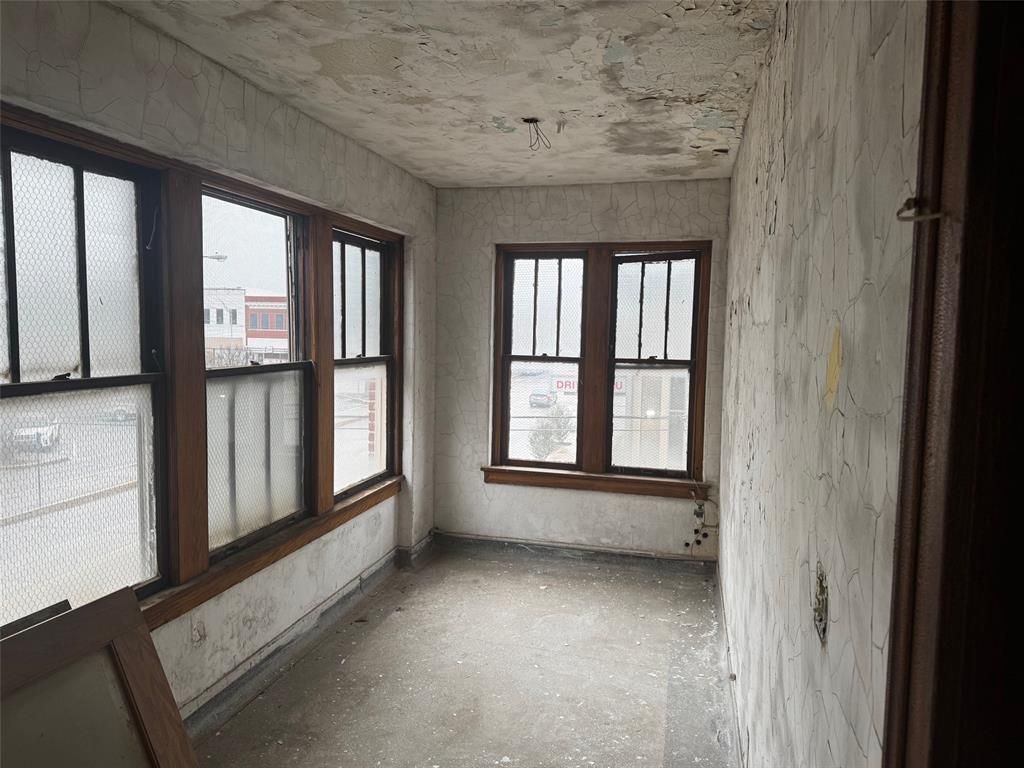 An empty room with a lot of windows and a ceiling.
